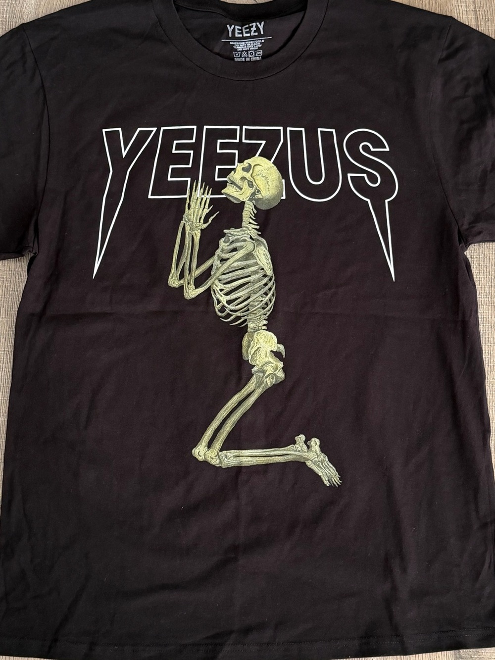 Yeezy Black T‑Shirt with Pale Yellow Praying Skeleton Graphic